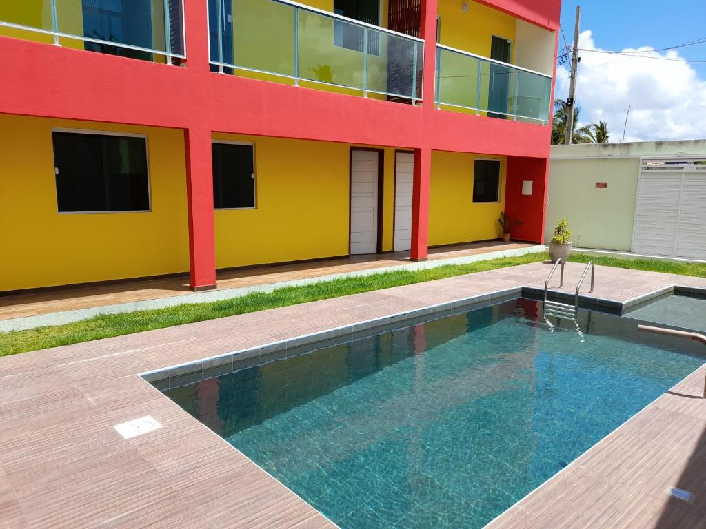 a building with a swimming pool in front of a building at Zen Spa Houses in São Miguel dos Milagres