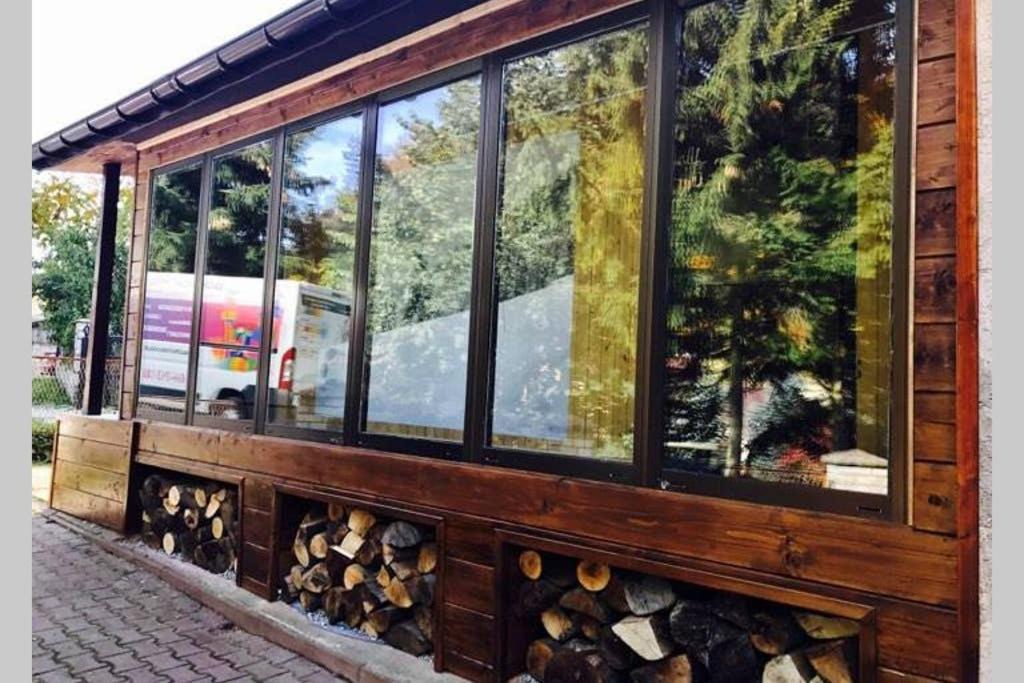 a building with many windows with logs in it at Domek Przy Stoku - Słotwiny in Krynica Zdrój