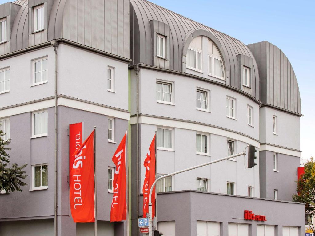 a building with red signs in front of it at ibis Mainz City in Mainz