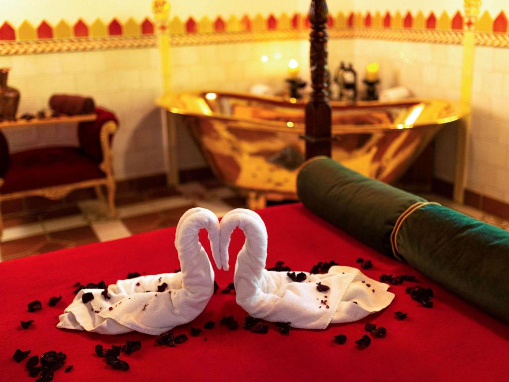 dos cisnes blancos están sentados en una alfombra roja en Hotel Mercure Krynica Zdrój Resort&Spa, en Krynica-Zdrój