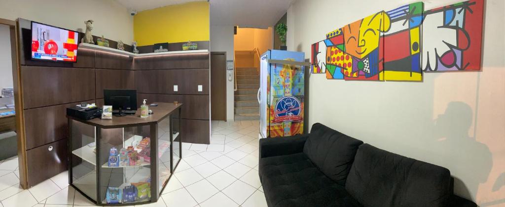 ein Zimmer mit einem Sofa und einem Tisch in einem Zimmer in der Unterkunft Pousada Cores in Navegantes