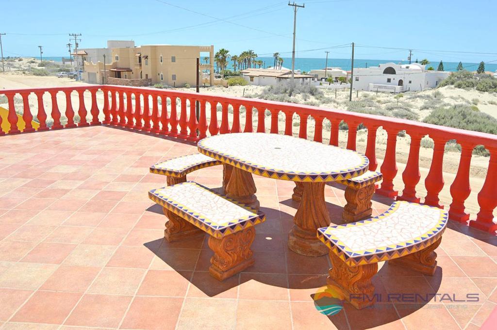 un balcón con mesa y 2 bancos en Casa Amarilla by FMI Rentals, en Puerto Peñasco