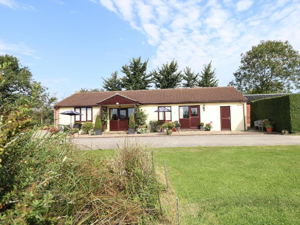 una casa con un patio de hierba delante de ella en Little Barn en Wincanton