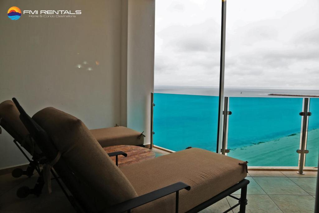 - un salon avec une chaise et une vue sur l'océan dans l'établissement Esmeralda #803 by FMI Rentals, à Puerto Peñasco