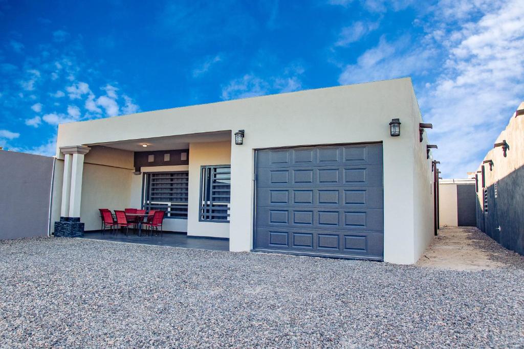 uma casa com uma porta de garagem e cadeiras vermelhas em Casa Bonita em Puerto Peñasco