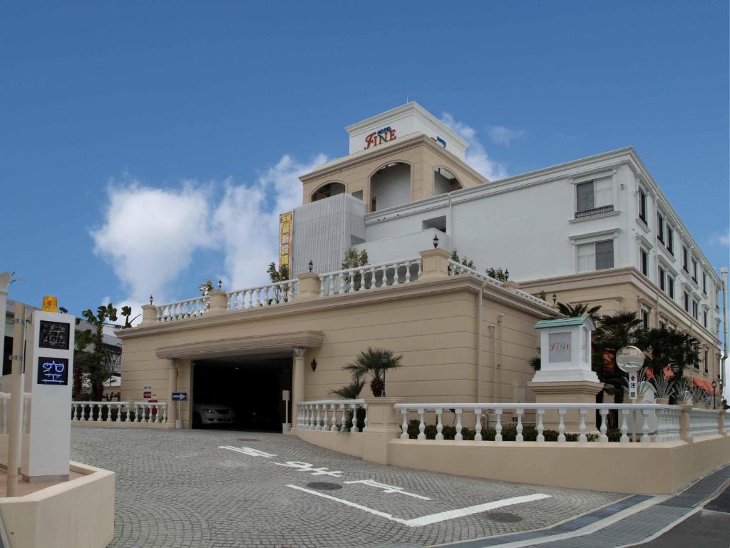 ein großes weißes Gebäude mit Balkon darüber in der Unterkunft Hotel Fine Garden Toyonaka Osaka International Itami Airport in Toyonaka