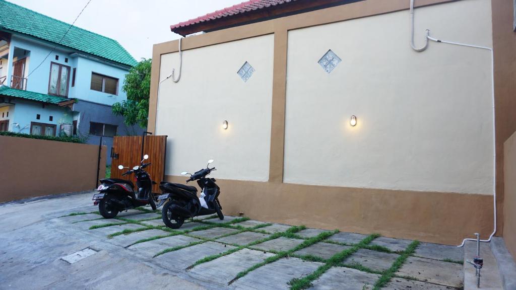 a couple of scooters parked next to a building at Jingga Homestay Balangan in Jimbaran