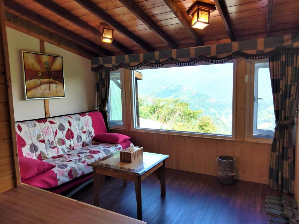 a living room with a couch and a table and a window at Shiyai Taoyuan in Ren&#39;ai