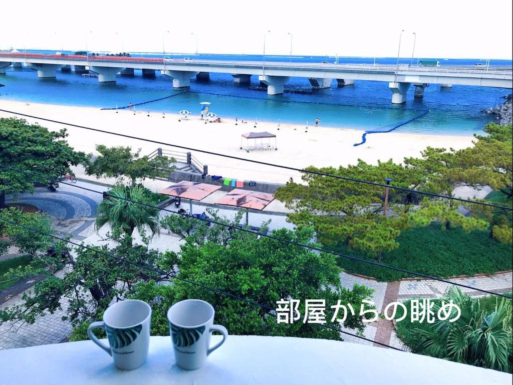 dos tazas sobre una mesa con vistas a un puente en Hotel GALA, en Naha