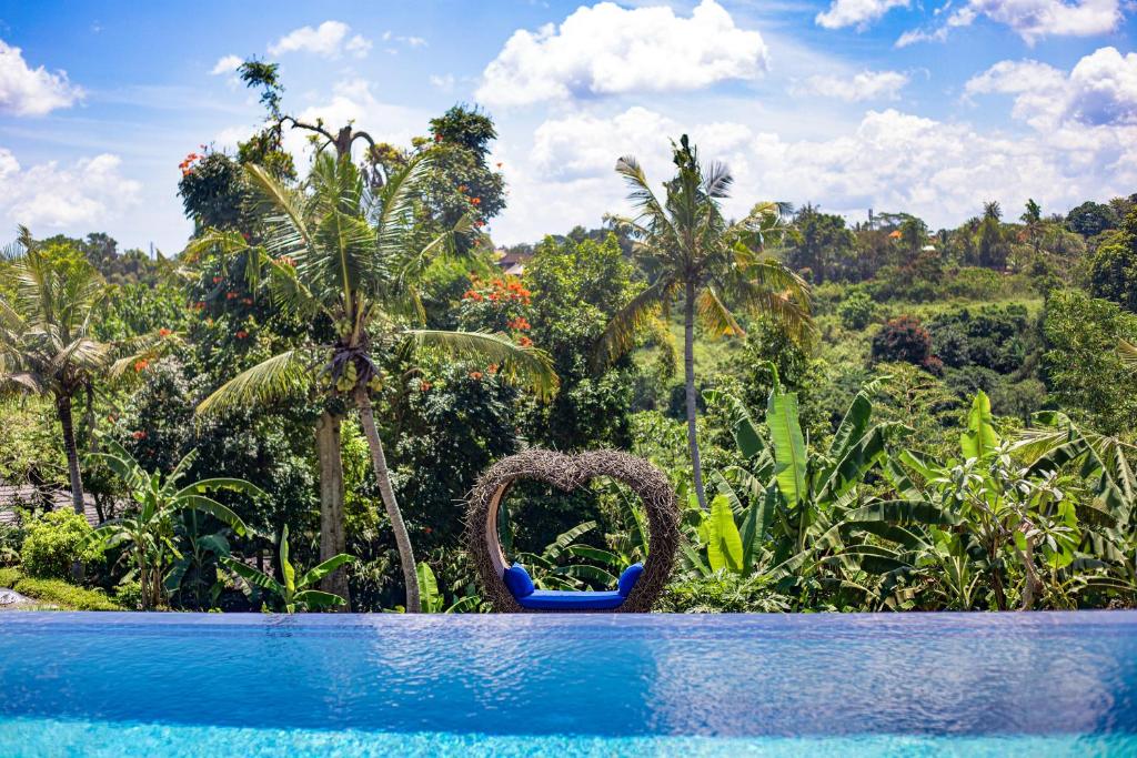 una piscina del resort con vista su una foresta di Wake in Paradise Lebah Villas Pool Kitchen Spa ad Ubud