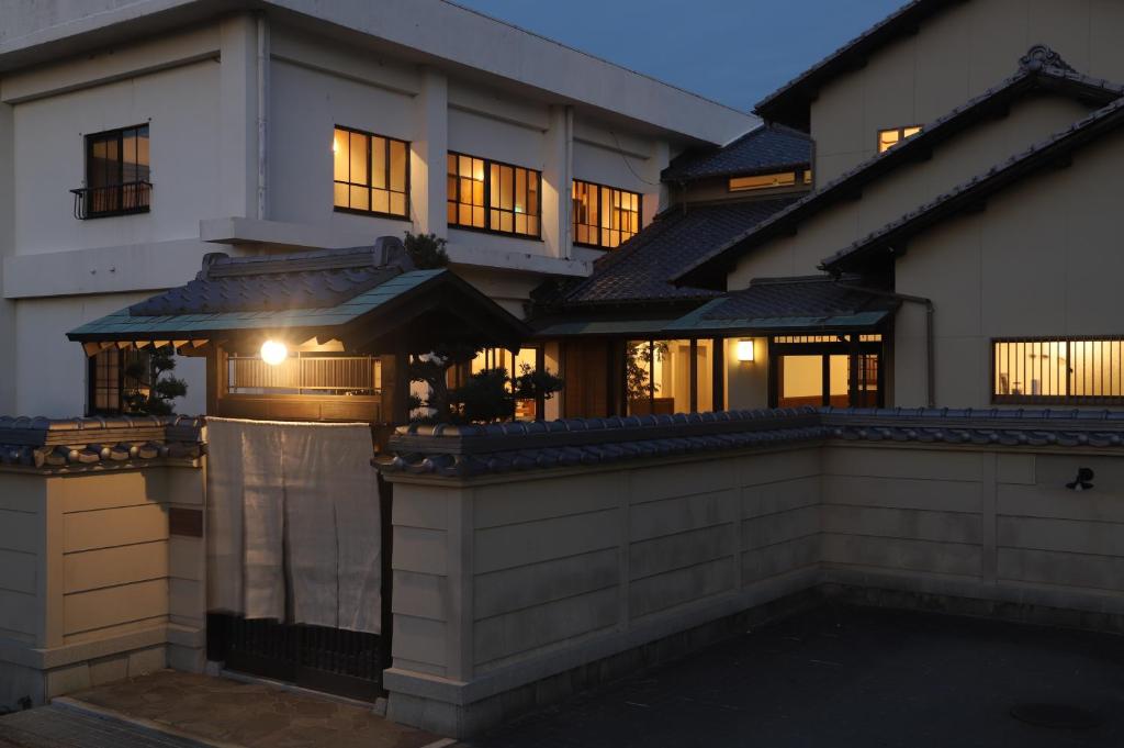 una casa con una puerta delante de ella en 淡路島西海岸の宿 梅木屋, en Sumoto