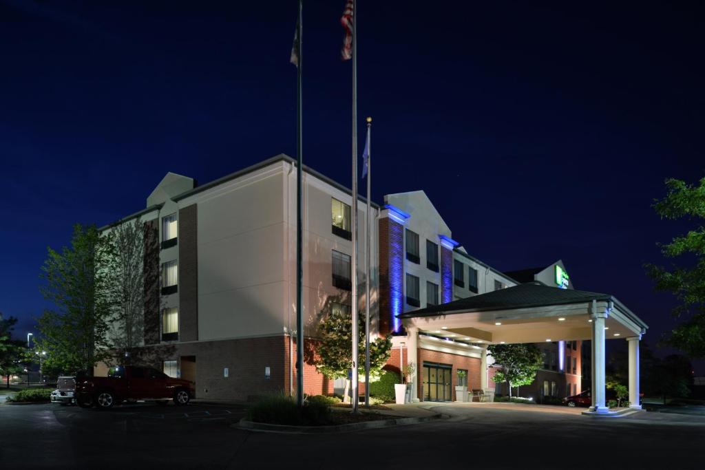 un edificio con una bandera encima de él por la noche en Holiday Inn Express Hotel & Suites Milwaukee-New Berlin, an IHG Hotel, en New Berlin