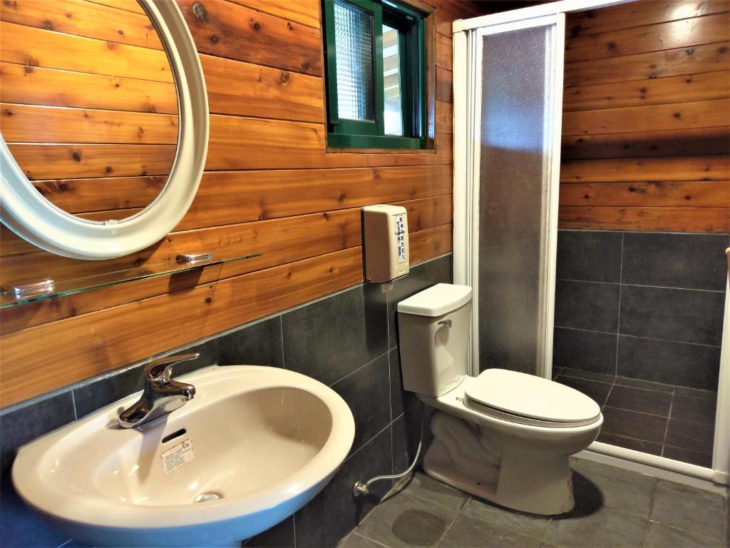 a bathroom with a sink and a toilet and a mirror at Shiyai Taoyuan in Ren&#39;ai