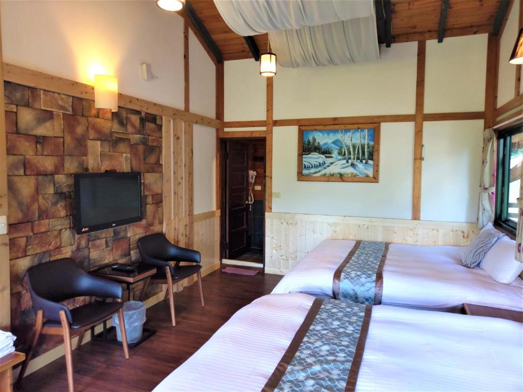 a hotel room with two beds and a tv at Shiyai Taoyuan in Ren&#39;ai