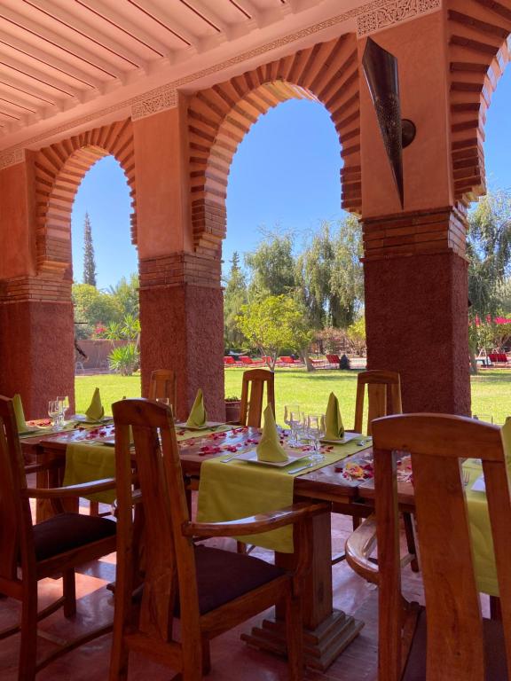 einen Holztisch mit grünen Tischdecken auf einer Terrasse in der Unterkunft LES JARDINS DE MARRAKECH in Marrakesch