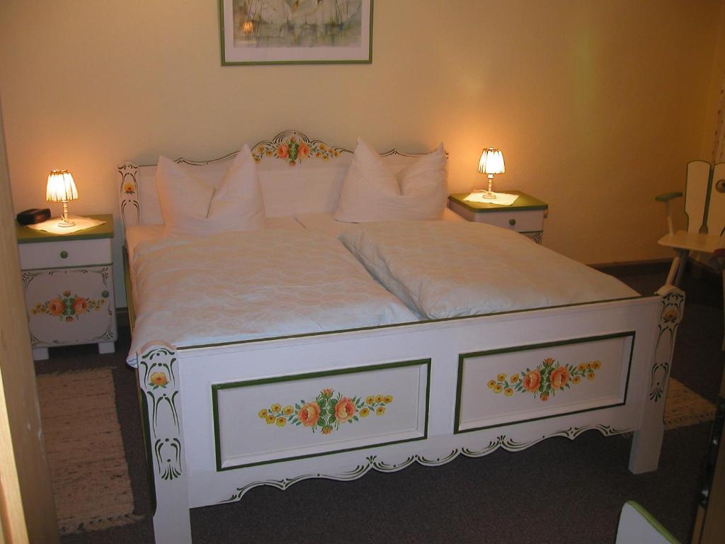 een slaapkamer met een wit bed en 2 nachtkastjes bij Ferienwohnungen Frosch in Bischofsgrün