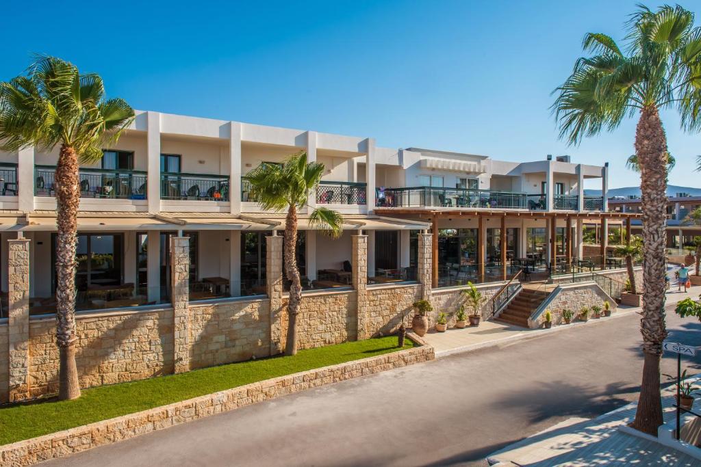 budynek z palmami przed nim w obiekcie Gouves Waterpark Holiday Resort w mieście Guwes