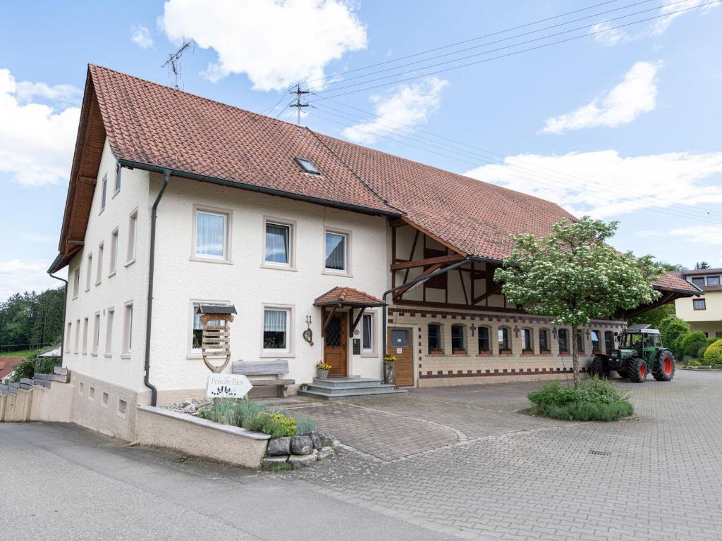 un grand bâtiment blanc avec un toit marron dans l'établissement Ferienhof Biegger, à Tettnang