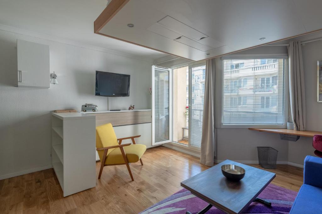 uma sala de estar com um sofá e uma mesa em StayParis em Issy-les-Moulineaux