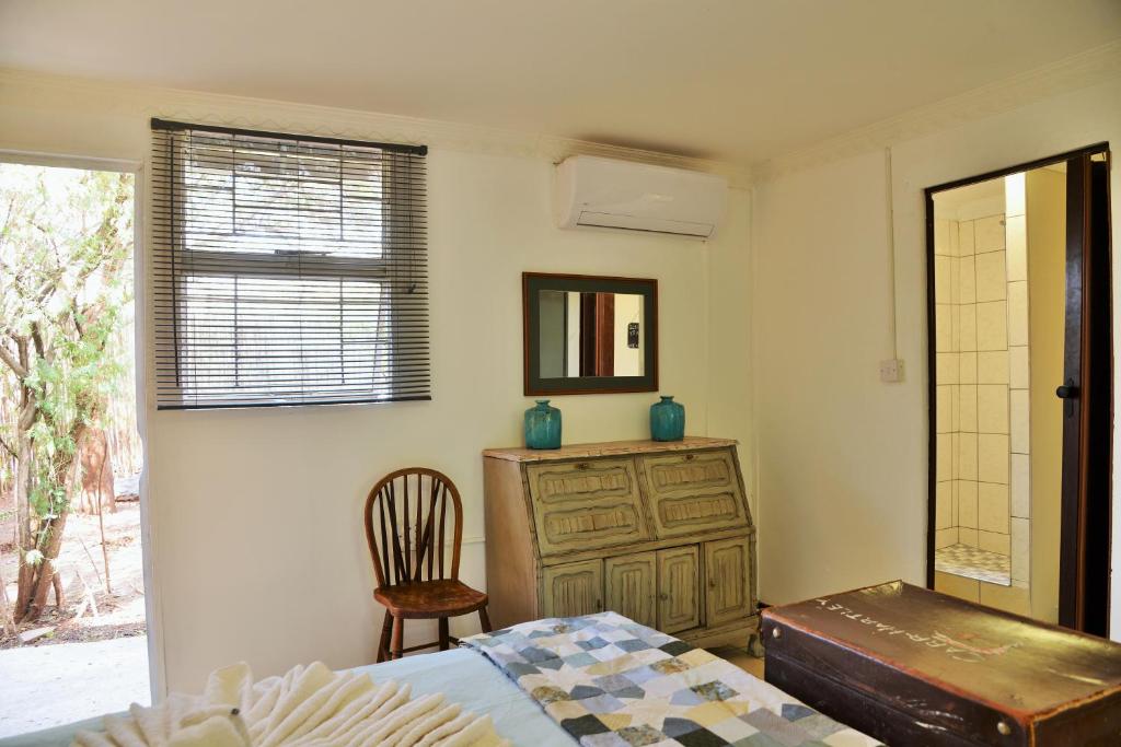 a bedroom with a bed and a dresser and a mirror at Kasane Self Catering in Kasane