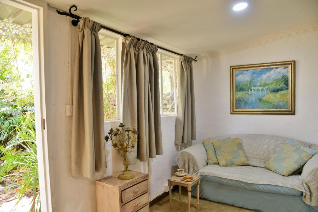 a living room with a couch and windows at Kasane Self Catering in Kasane