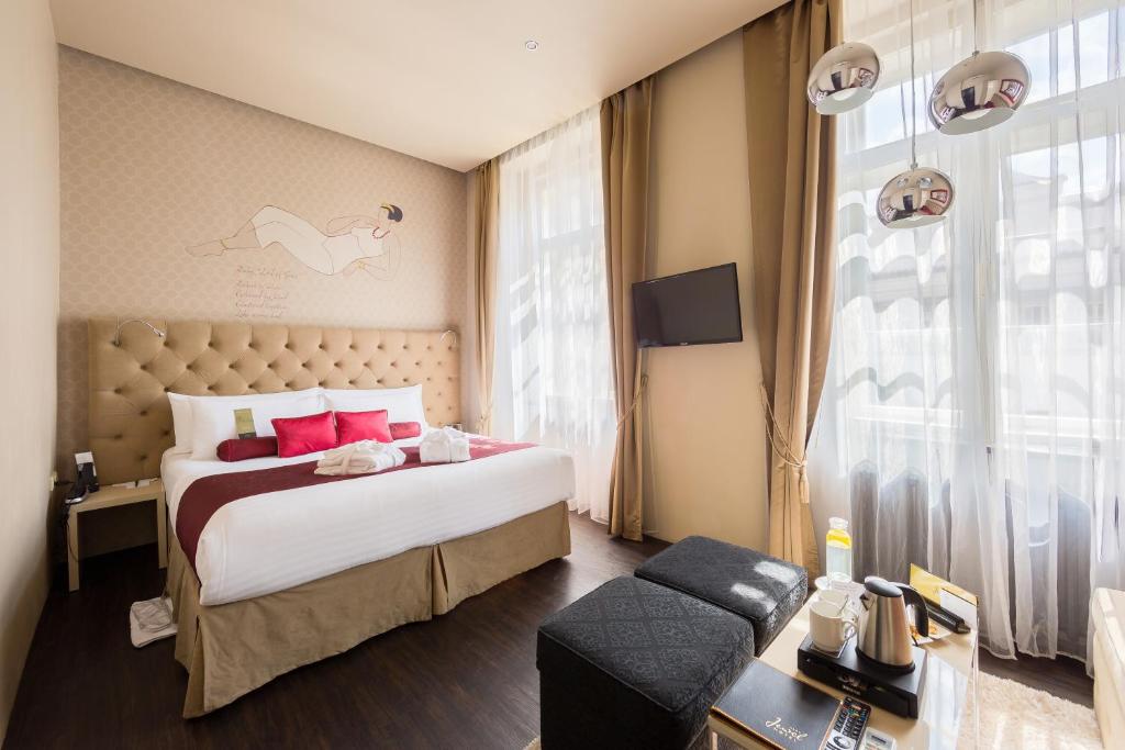 ein Schlafzimmer mit einem großen Bett und einem großen Fenster in der Unterkunft Design Hotel Jewel Prague in Prag