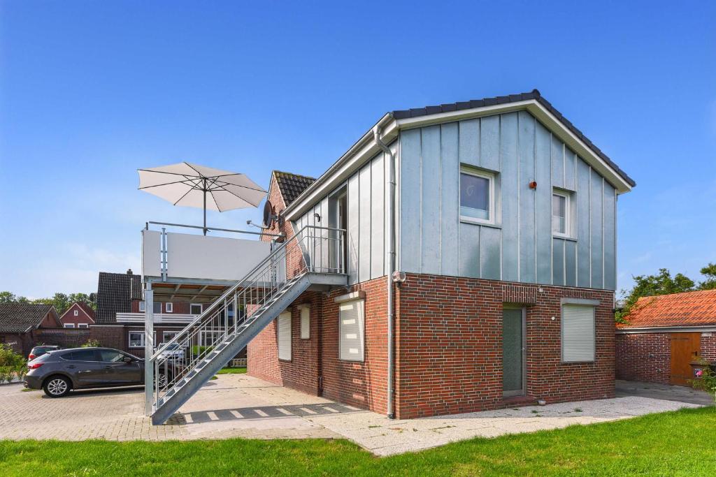 a house with a staircase on the side of it at Ferienwohnung Teezeit in Neuharlingersiel