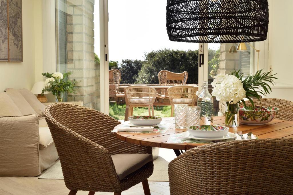 a dining room with a table and wicker chairs at Punta Ala Sea View Apartments in Punta Ala