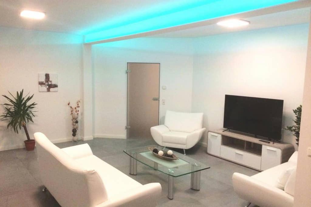 Una sala de estar con muebles blancos y un televisor de pantalla plana. en Elegantes Haus im Dresdner Süden, en Bannewitz