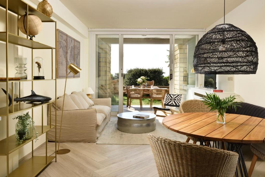 a living room with a table and a couch at Punta Ala Sea View Apartments in Punta Ala