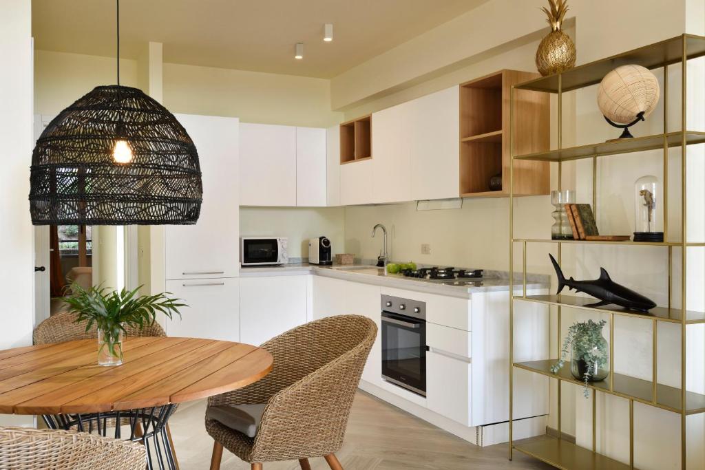 a kitchen with white cabinets and a wooden table at Punta Ala Sea View Apartments in Punta Ala