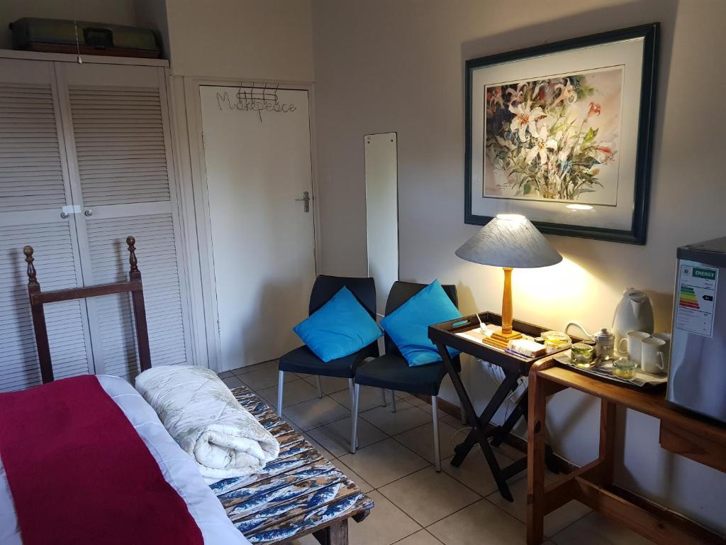 - une chambre avec un bureau, un lit et un bureau avec une lampe dans l'établissement Fairway cottage, à Port Edward