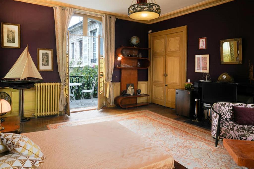 a living room with a couch and a chair and a door at la Forge du Roy in Blois