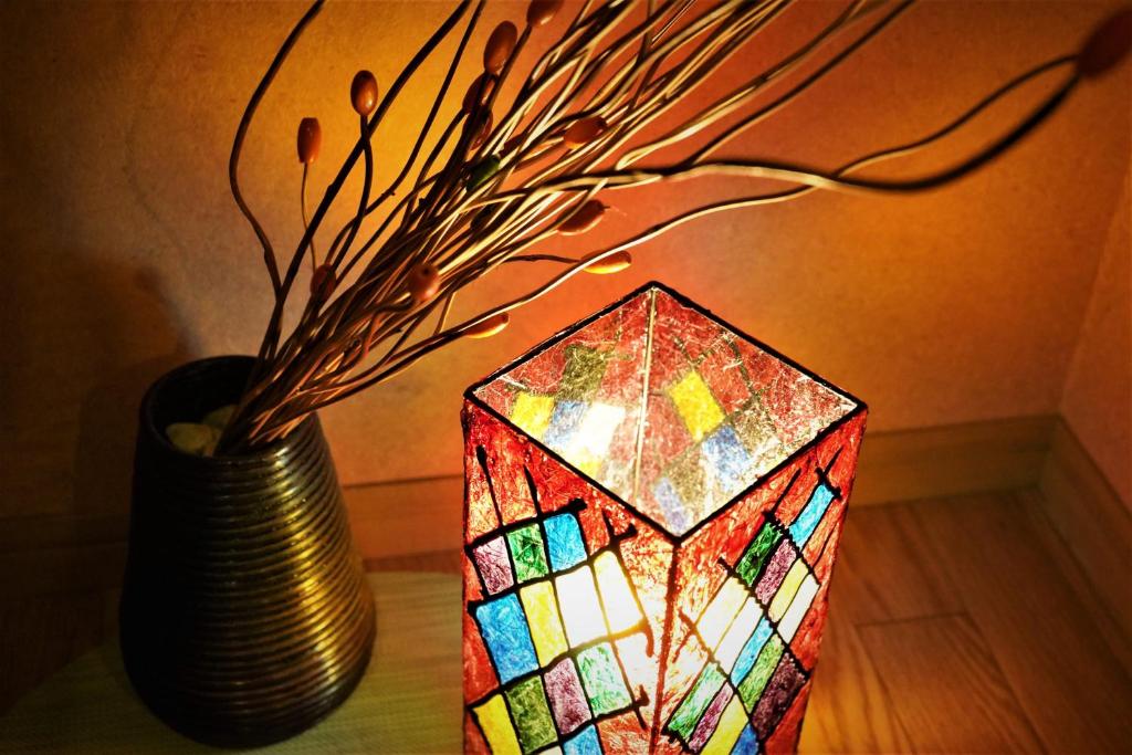 un vase avec un cube de verre teinté à côté d'une lampe dans l'établissement Ryokan Shimizu, à Kyoto