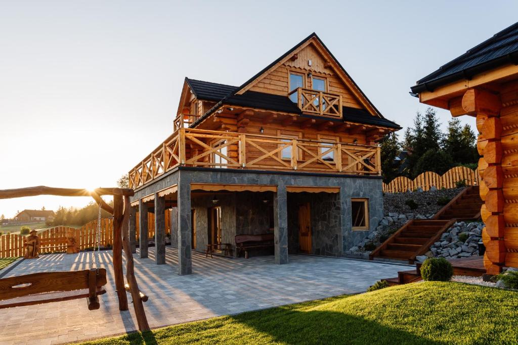 ein großes Holzhaus mit einer großen Terrasse in der Unterkunft Widokowa Chata Istebna Trójwieś in Istebna