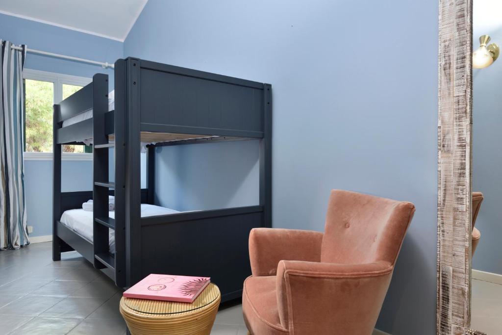a bedroom with a bunk bed and a chair at Punta Ala Sea View Apartments in Punta Ala