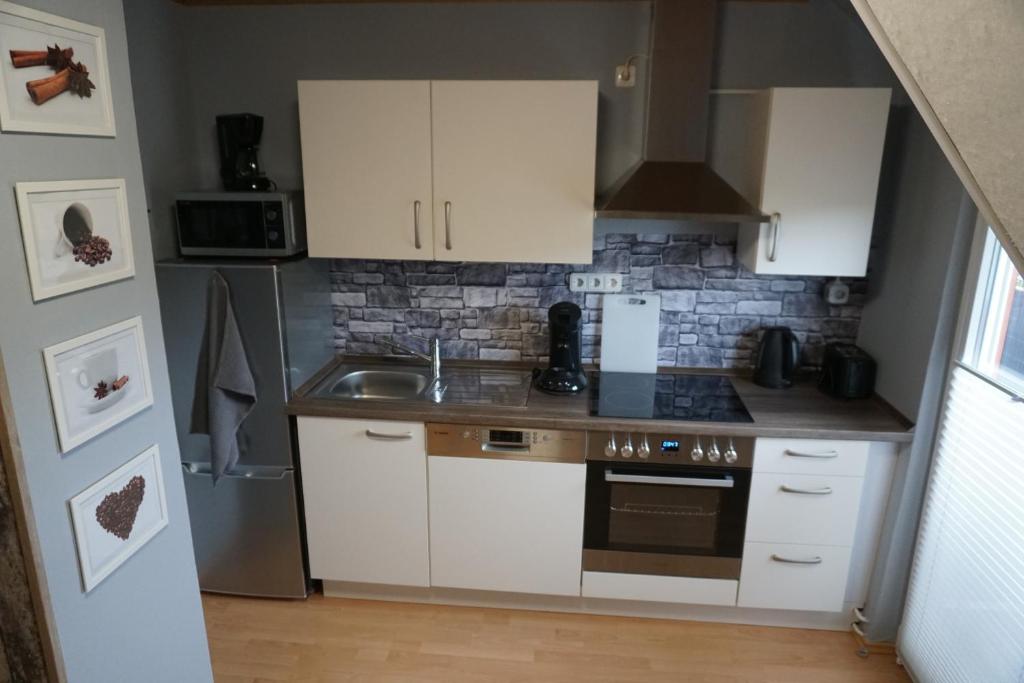 a small kitchen with white cabinets and a sink at Ferienwohnung Waldblick in Bad Wildungen