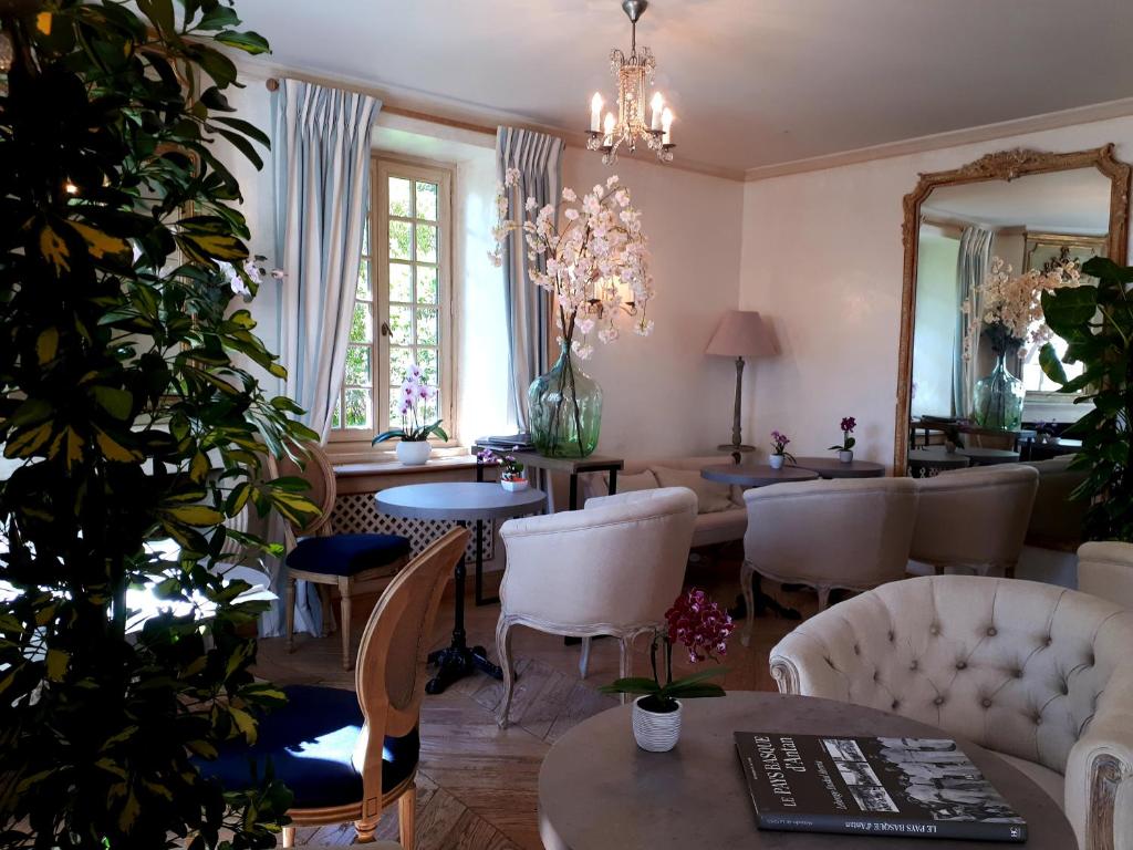 a living room with tables and chairs and a mirror at Hotel Villa Catarie in Guéthary