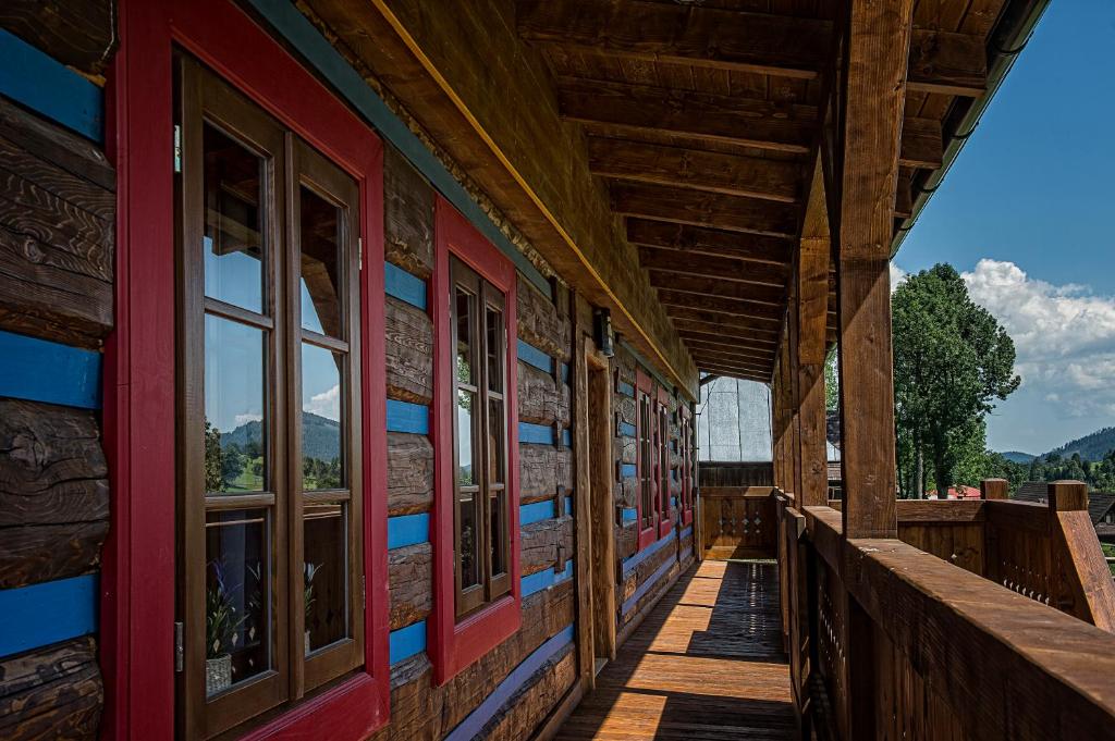 a porch of a wooden house with windows at Mountain Resort Ždiar - River in Ždiar