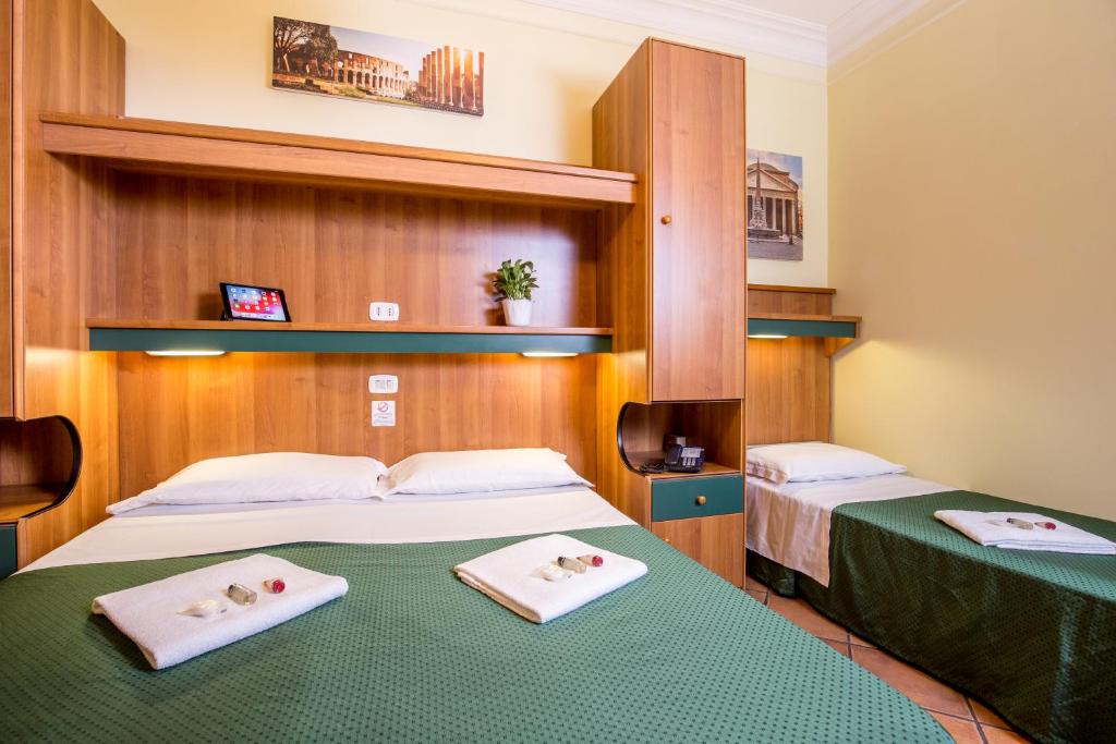 two beds in a hotel room with towels on them at Hotel Trastevere in Rome