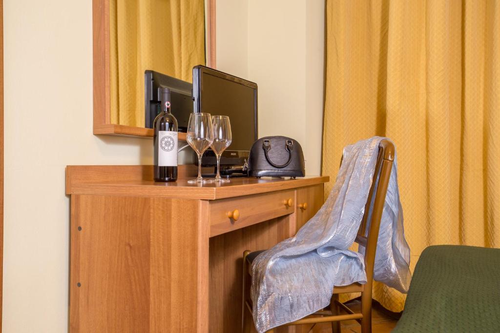 a room with a desk with a television and wine glasses at Hotel Trastevere in Rome