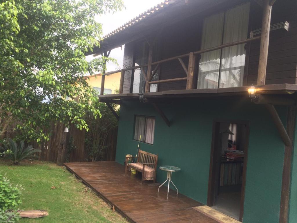 Casa azul con terraza de madera con mesa en Linda casa na Gamboa Garopaba, en Garopaba