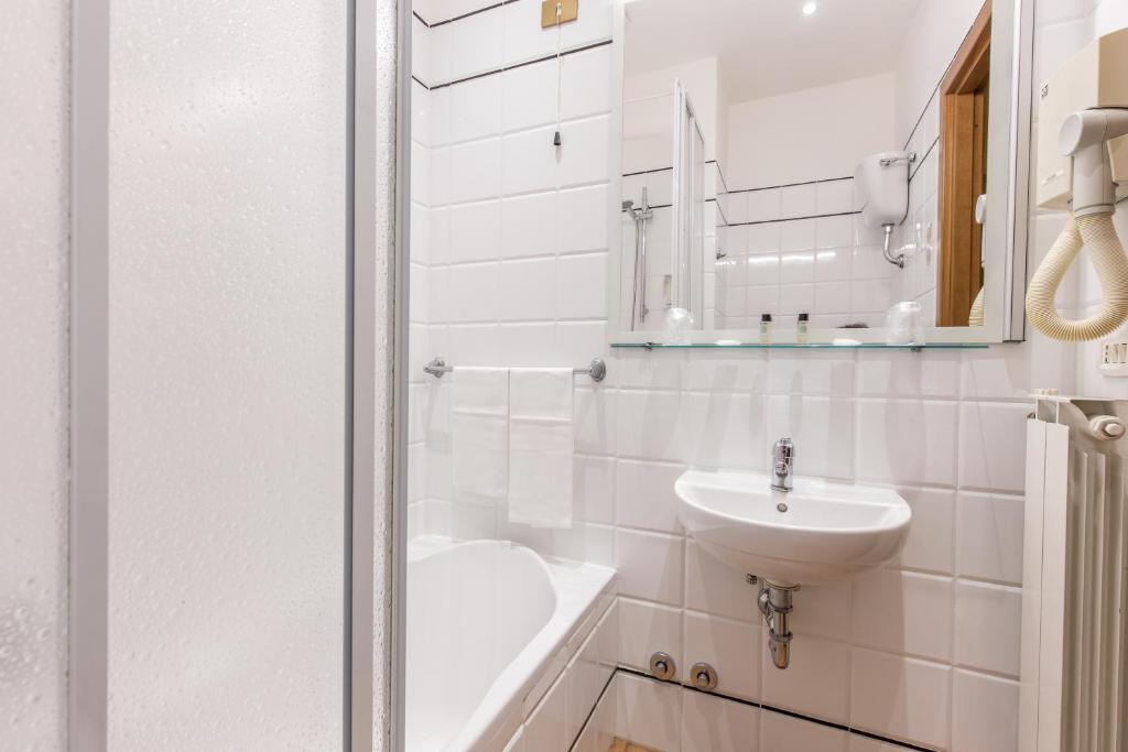a white bathroom with a sink and a mirror at Hotel Trastevere in Rome