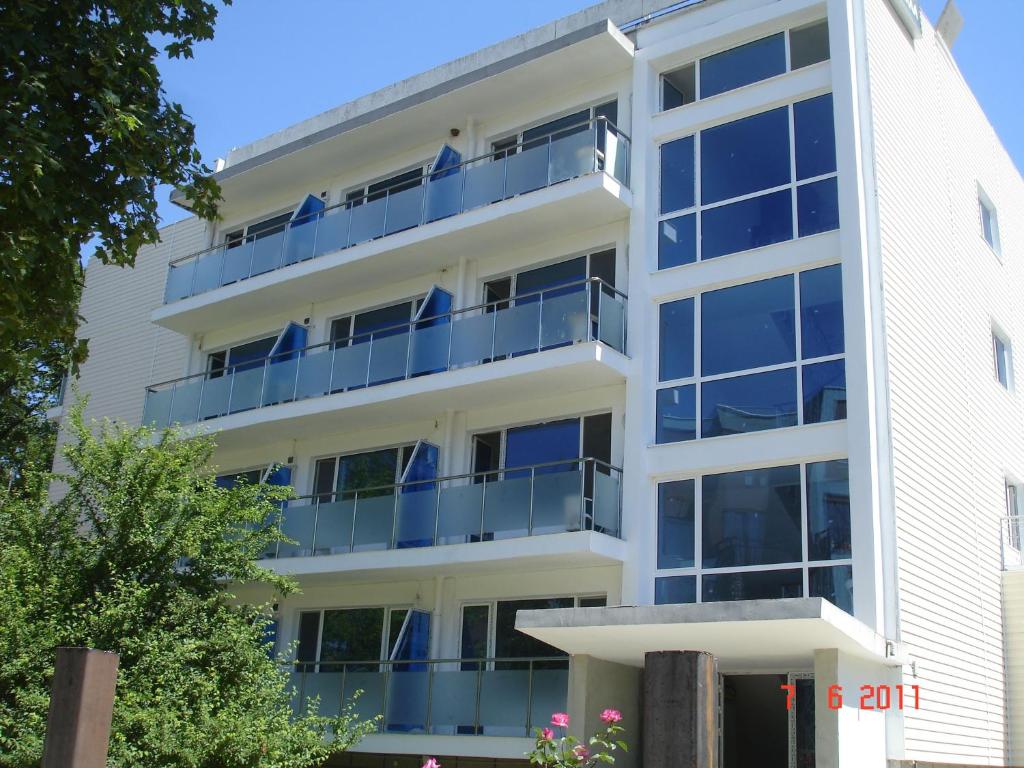 um edifício de apartamentos com varandas azuis em Hotel Park 1 em Kiten