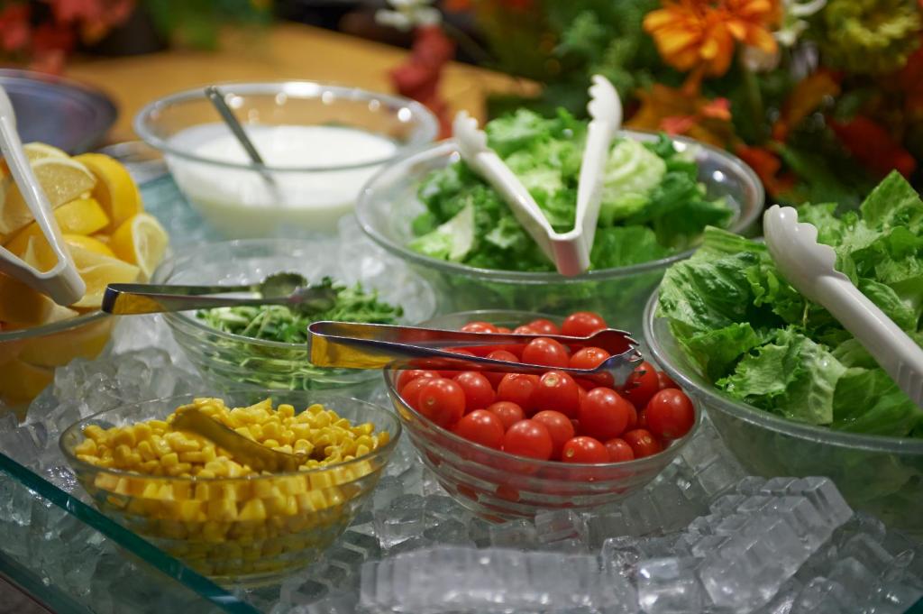 a table topped with bowls of tomatoes and vegetables at Sotetsu Fresa Inn Higashi Shinjuku in Tokyo