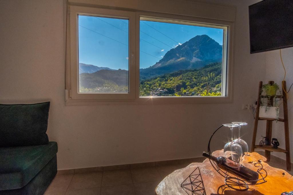 a living room with a large window and a table at Remvi GUEST HOUSE in Pramanta