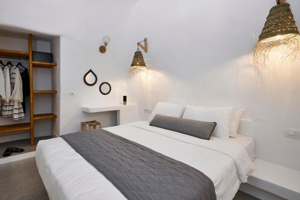 - une chambre avec un grand lit blanc et quelques lumières dans l'établissement Luxury Santorini Villa Superior Cave Villa Outdoor Hot Tub Oia, à Oia