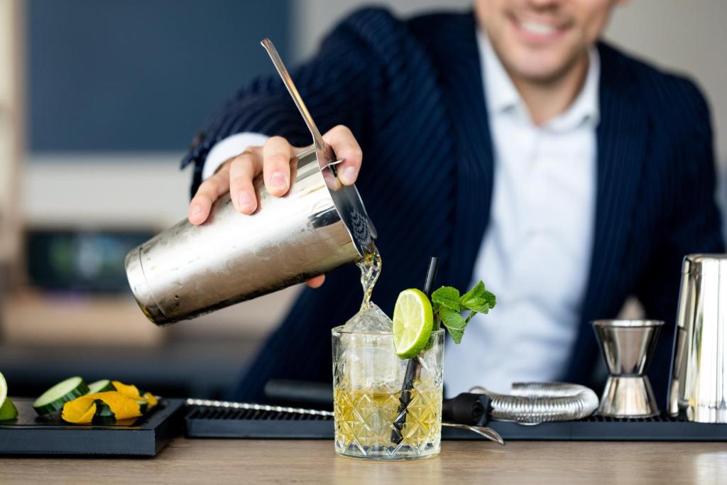 a man pouring a drink into a glass at Holiday Inn Express Amsterdam - North Riverside by IHG in Amsterdam