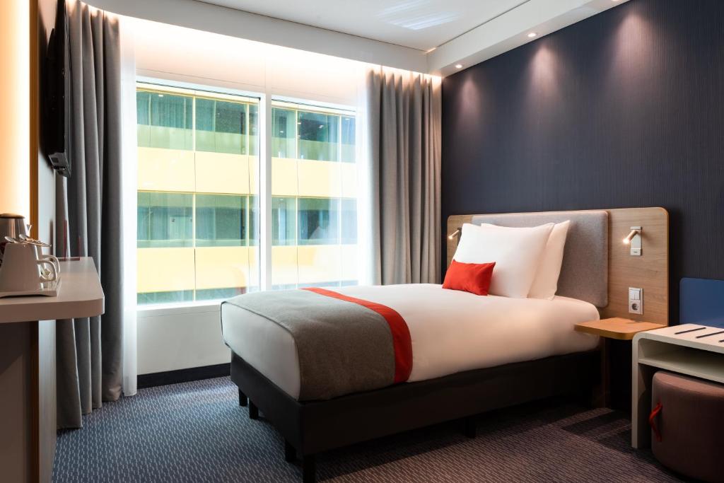 a hotel room with a bed and a window at Holiday Inn Express Amsterdam - North Riverside by IHG in Amsterdam