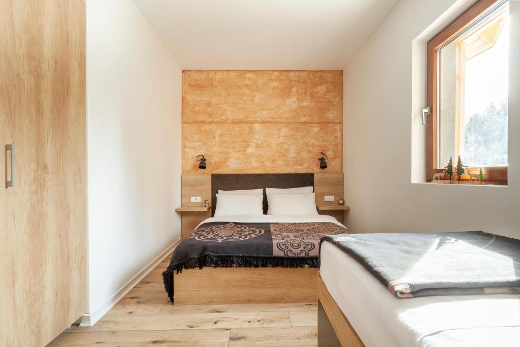 a bedroom with two beds and a window at Chalet Vrhovi Kopaonika in Kopaonik